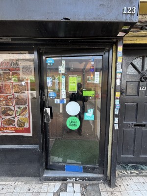 Glass door with black frames. Push from left to open.