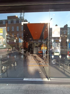 Glass door with silver handle on left. Push to open.