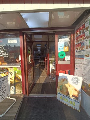 Glass door with brown, metal frame. Push from right to open. A-frame board on right before entrance.