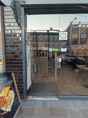 Glass door with silver handle on right. Push to open.