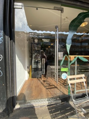 Glass door ahead. Pull from metal handle on right to open