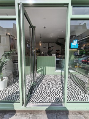 Green framed glass door. Push silver handle on right to open.