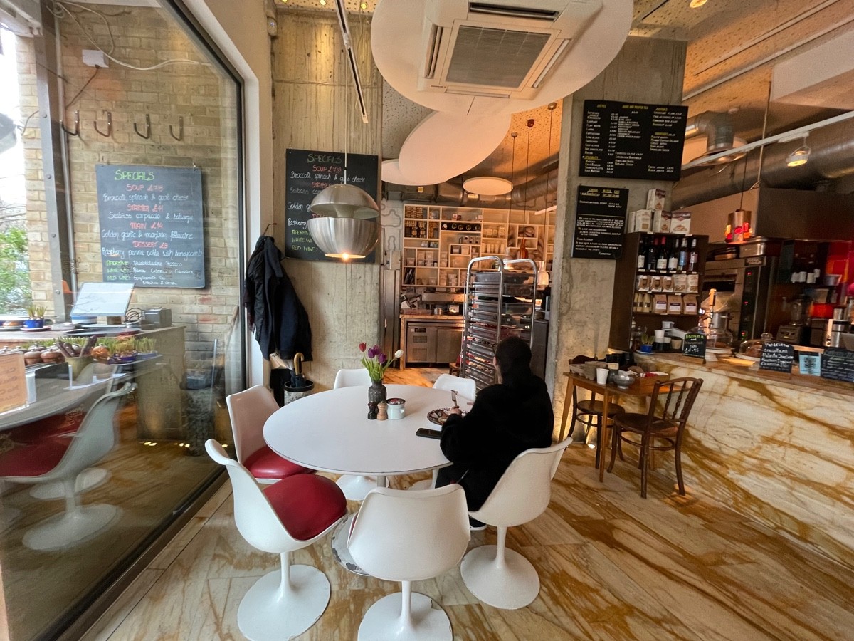 From entrance facing left. Tables and chairs ahead. Counter along right.