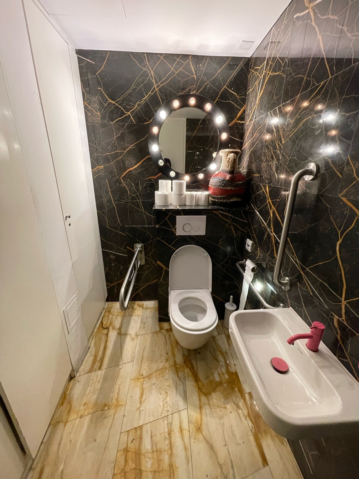 From doorway facing straight. Toilet at back. Sink on right.