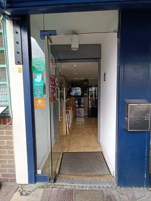 Glass door with silver handle on right. Push to open.
