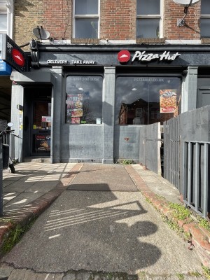 From pavement facing venue. Very steep ramp up to door at back left