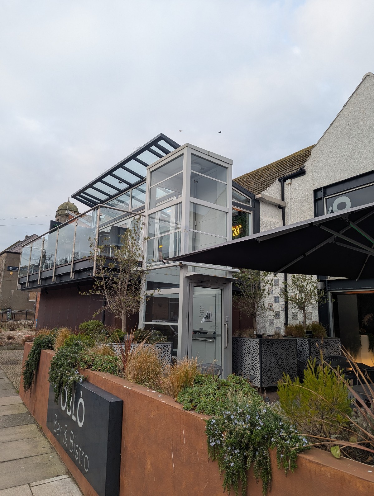 Main frontage of Oblo showing lift. Oblo is upstairs, Giacopazzi's Gelato & fish & chips are downstairs. Also has outdoor seating & canopy umbrella
