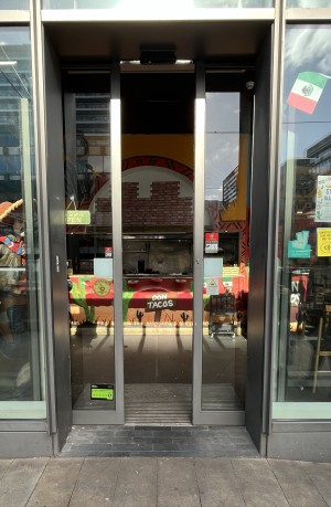 Automatic double doors with grey frame in motion.