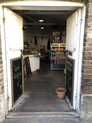 White doors, push from centre to open. Plant pot on right.
