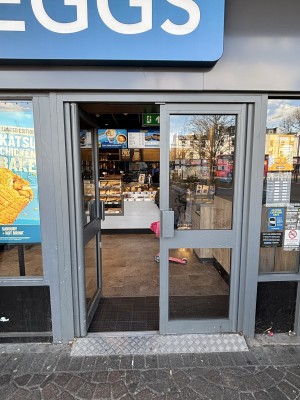 Glass doors with grey frames ahead. Push from center to open.