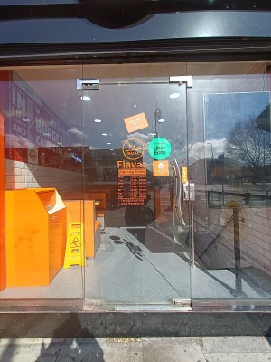 Glass door with silver handle on right. Push to open.