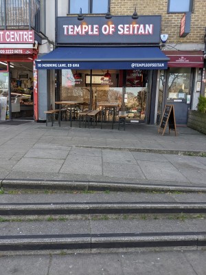 From pavement facing venue. Three steps up ahead, followed by end of ramp. Door to venue back right.