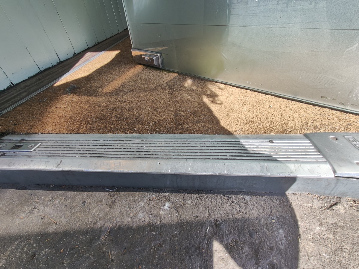 Small step up on threshold of door followed by doormat.