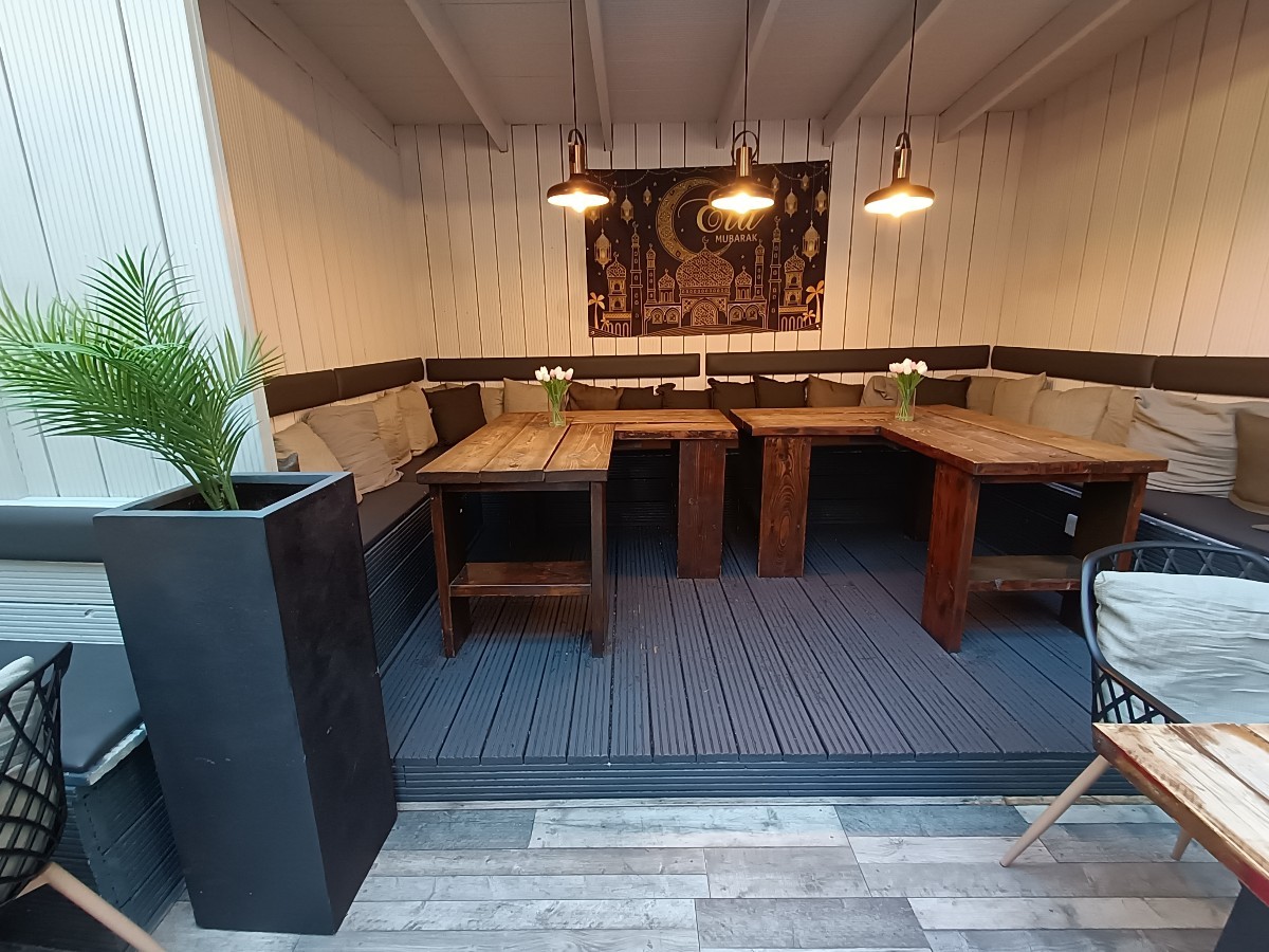 From end of tables and chairs, looking straight. Step up at back to half-booths and tables.