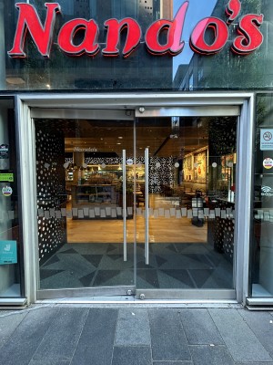 Glass doors with grey frame. Push silver handles in centre to open.
