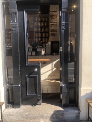 Glass doors with black frame. Push from centre to open.