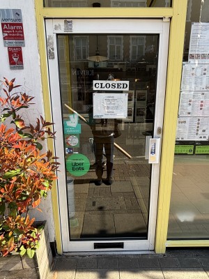 Glass door with white frame. Push to open from right.