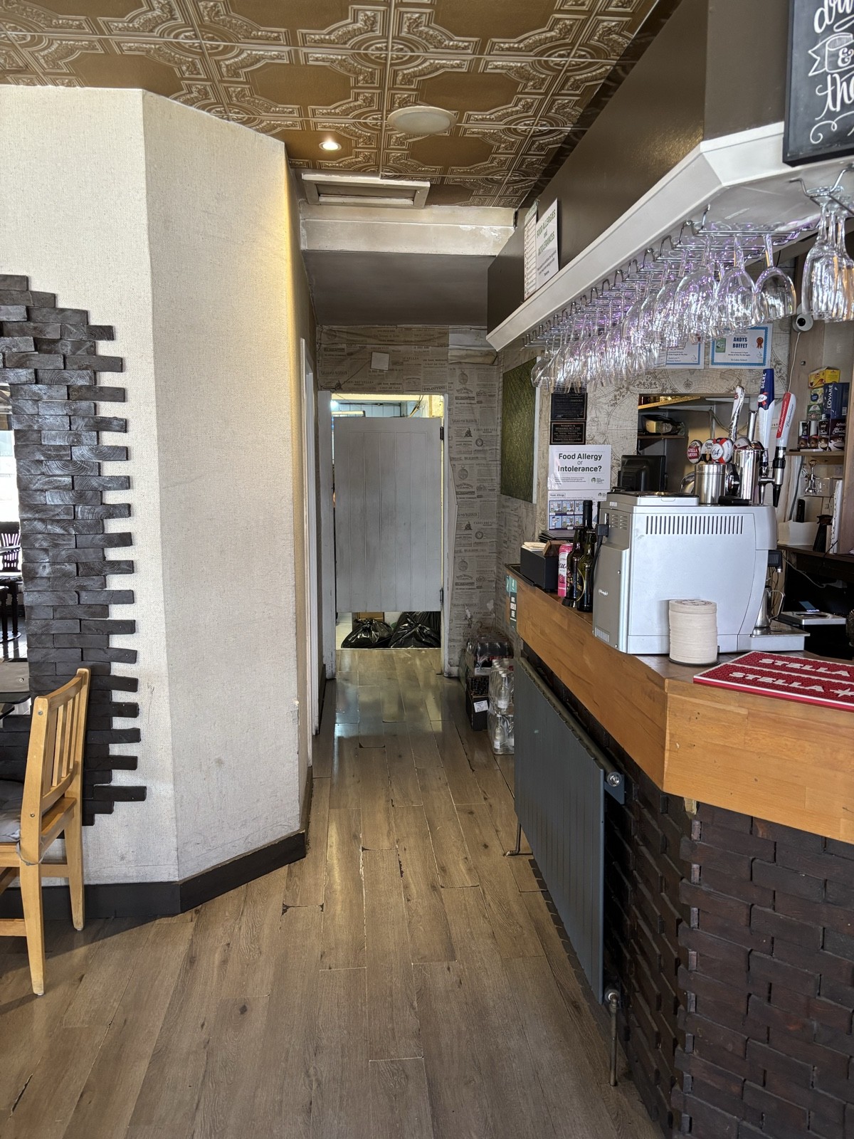 From left of bar counter facing straight. Path ahead. Toilet at the back.