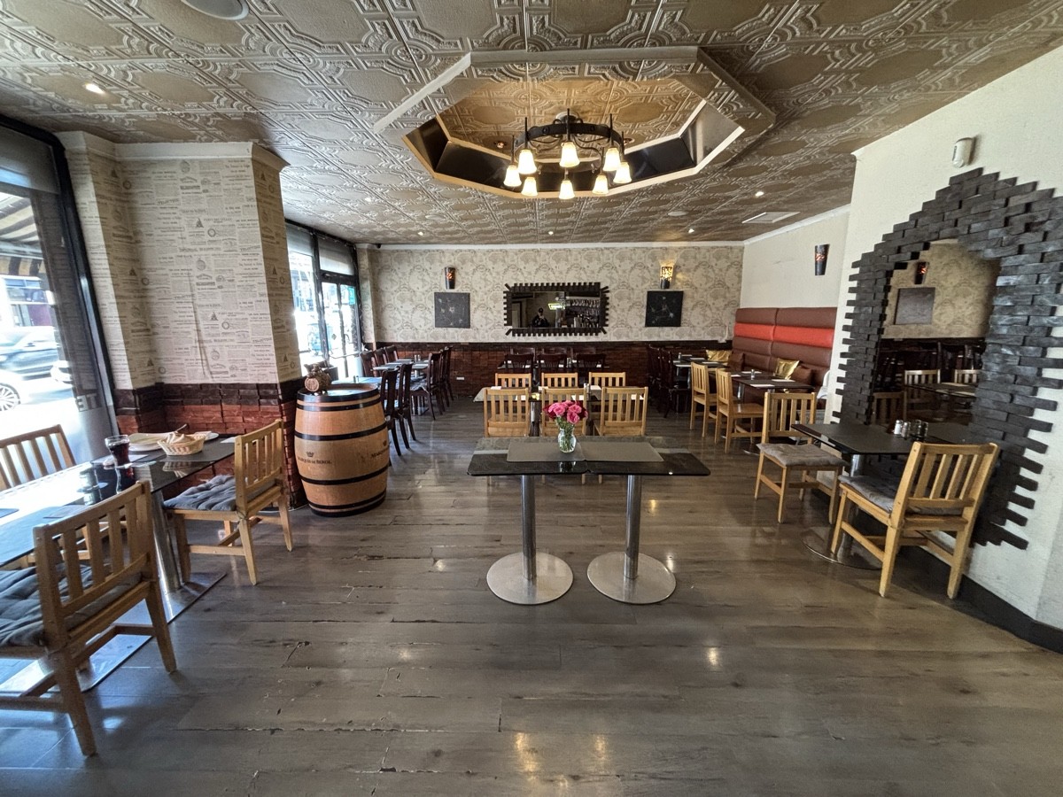 From left of bar counter facing left. Tables and chairs along left, centre and right.
