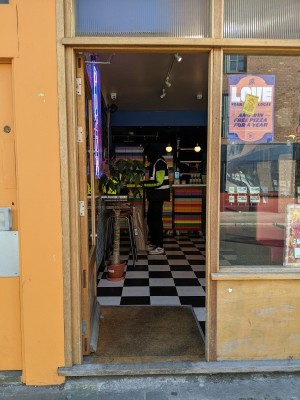 Glass door with wood frame. Push from right to open.
