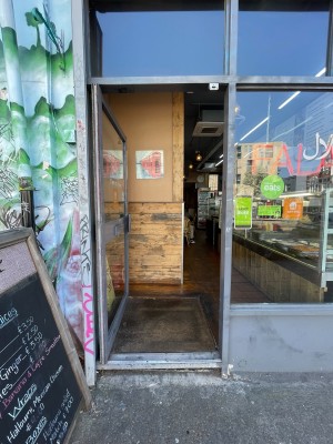 Metal-framed glass door. Push from metal handle on right to open.