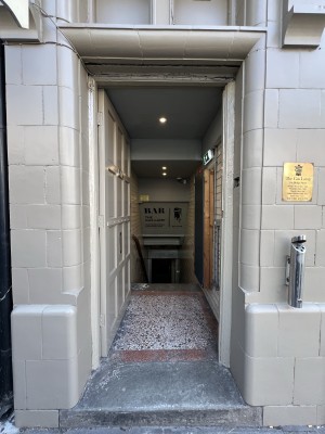 Preceding white door. Push on right to open.
