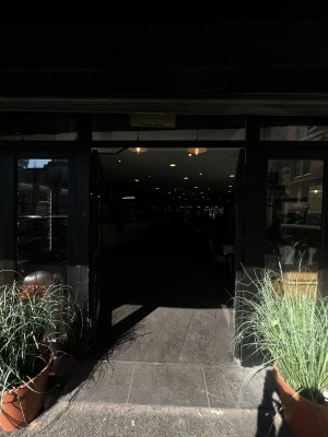 Black and glass door facing straight. Push in the middle to open.
