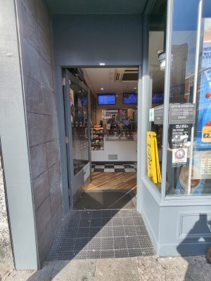 Grey framed glass door. Push silver handle on right to open.
