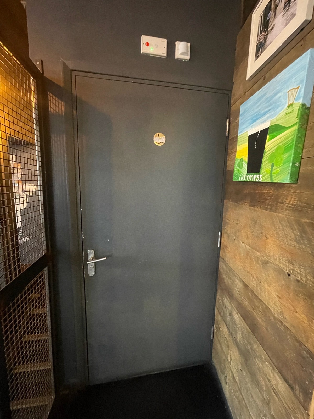 Facing gray blue toilet door. Pull sliver handle on left.