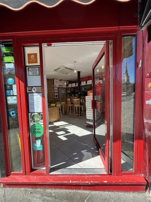 Glass door with red frames ahead. Push from left to open.