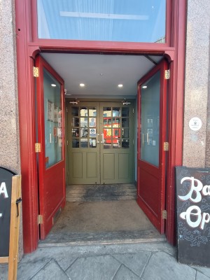 Preceding red framed glass doors. Push from centre to open.