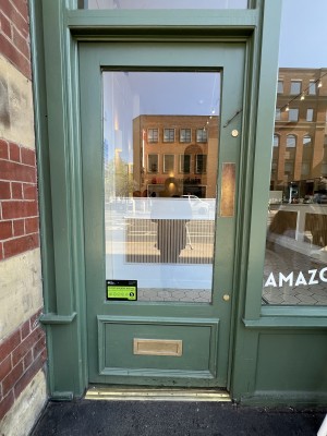 Green framed glass door. Push on right to open.