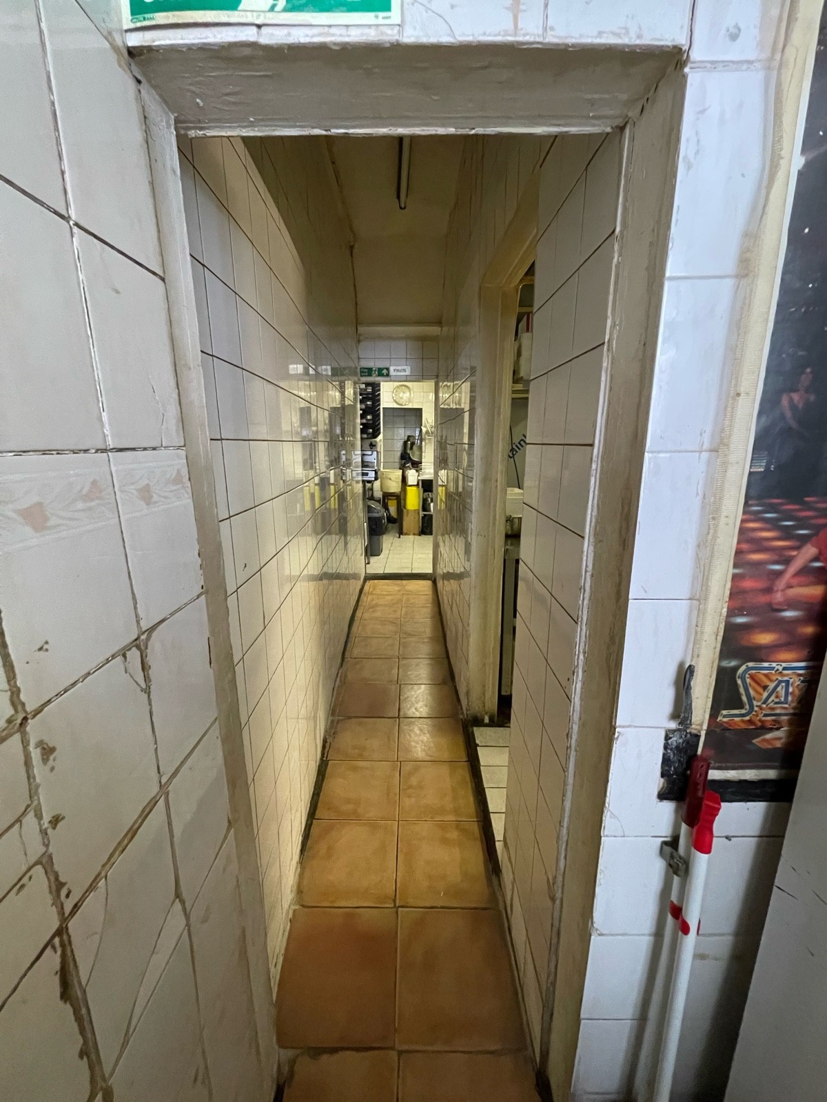 From after half booth seating facing straight. Opening ahead. Hallway following.
