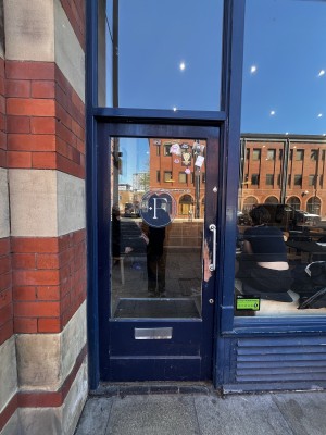 Glass door with blue frame. Push silver handle from right to open.