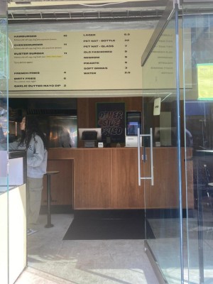 Glass door with silver handle on left. Push to open.