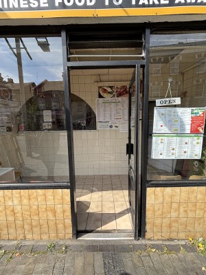 Glass door with black frame. Push via handle on left to open.