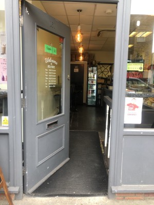 Glass door with grey frame. Push from right to open.