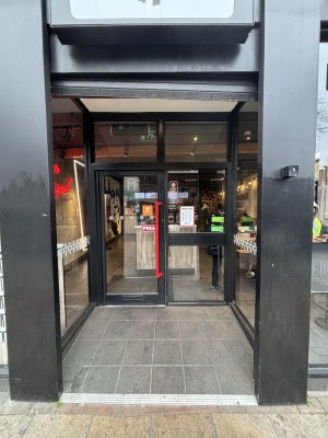From pavement facing venue. Opening ahead. A built in ramp slopes up to door at the back.