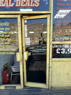 Glass door with yellow frame. Push yellow handle from left to open.