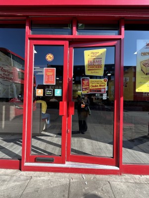 Glass doors ahead with red frame. Push red handles in centre to open.