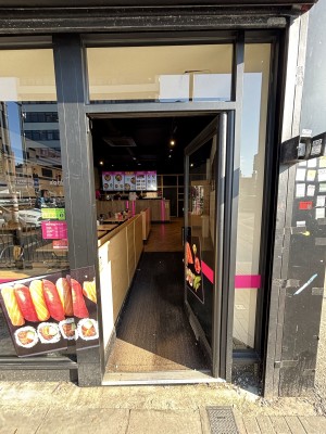 Glass door with grey frame ahead. Push door from left to open.