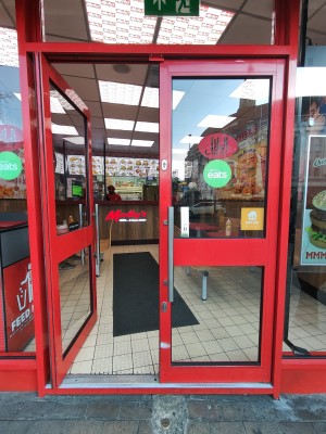 Red framed glass doors. Push silver handles in centre to open.