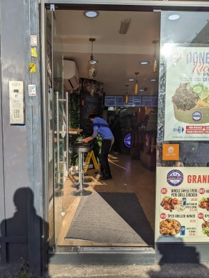 Glass door with metal handle on right. Push to open.
