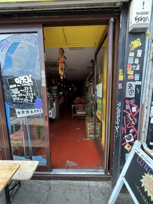 Glass door with brown frames. Push from left to open.