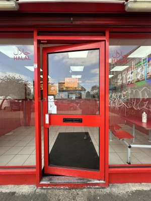 Glass door with red frame. Push red handle from left to open.
