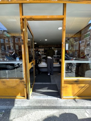 Glass door with yellow frame. Push yellow handle from right to open.