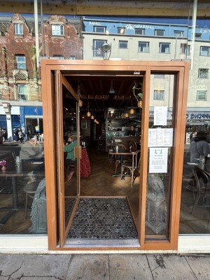 Glass door with brown frames ahead. Push from right to open.