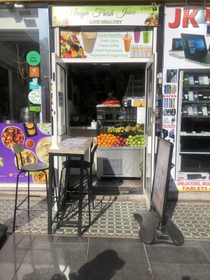 From pavement facing venue. Outdoor seating ahead to left. Counter behind at back.
