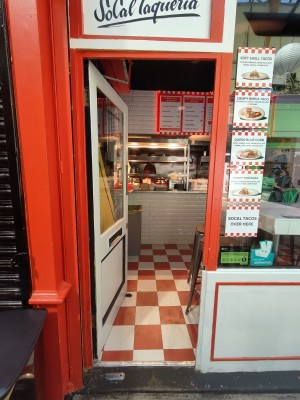 Red framed white glass door. Push from right to open.