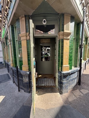 Glass door with green frames. Pull from right to open.